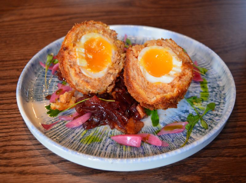 Cornflake-crushed Scotch egg served with bacon and mustard jam, watercress and pickled shallots