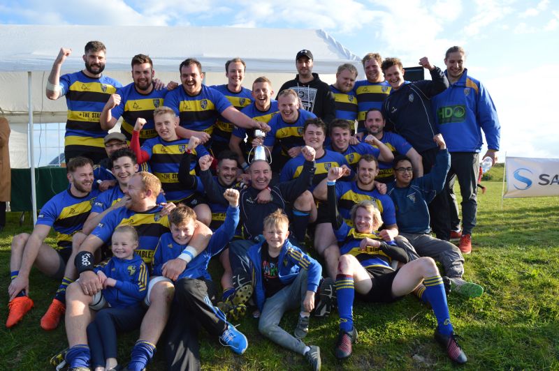 Cheltenham Saracens’ players celebrate their Senior Cup win with coaches Billy Burns and Jacob Rowan