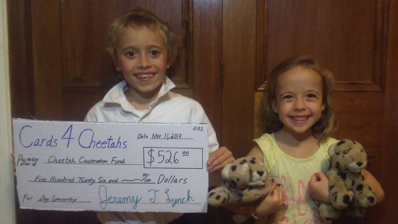 Jeremy Lynch holds a cheque for the Cheetah Conservation Fund
