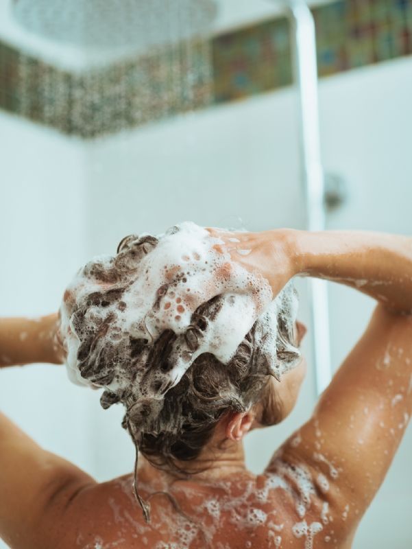 Woman washing hair in shower
