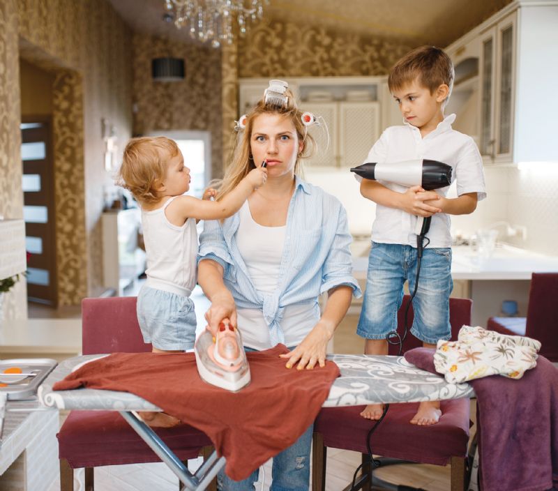 Mum with two kids juggling ironing house chores