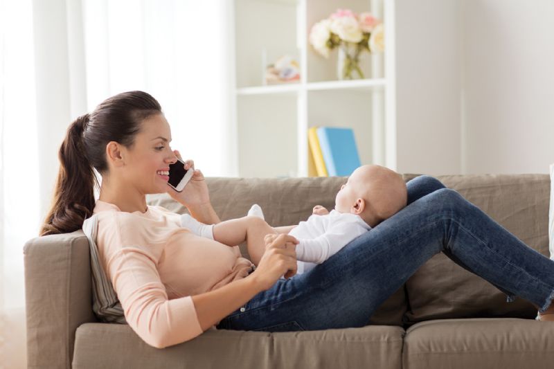 Mum with young baby talking on phone to friend